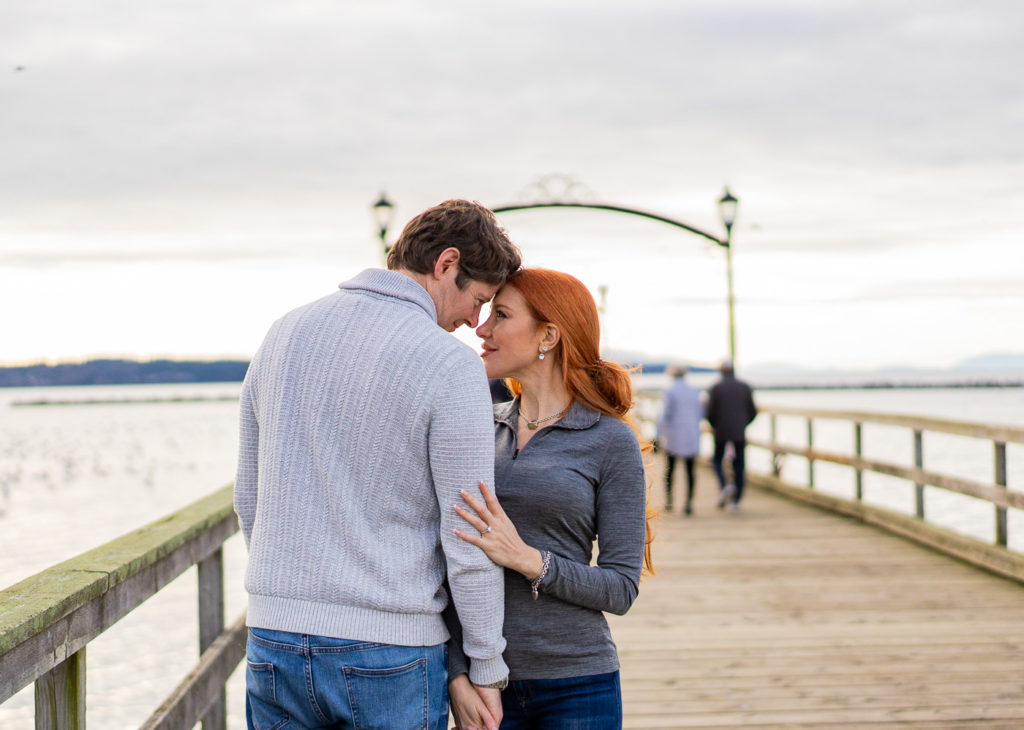 White Rock Pier with a newly engaged couple holding hands for their engagement session