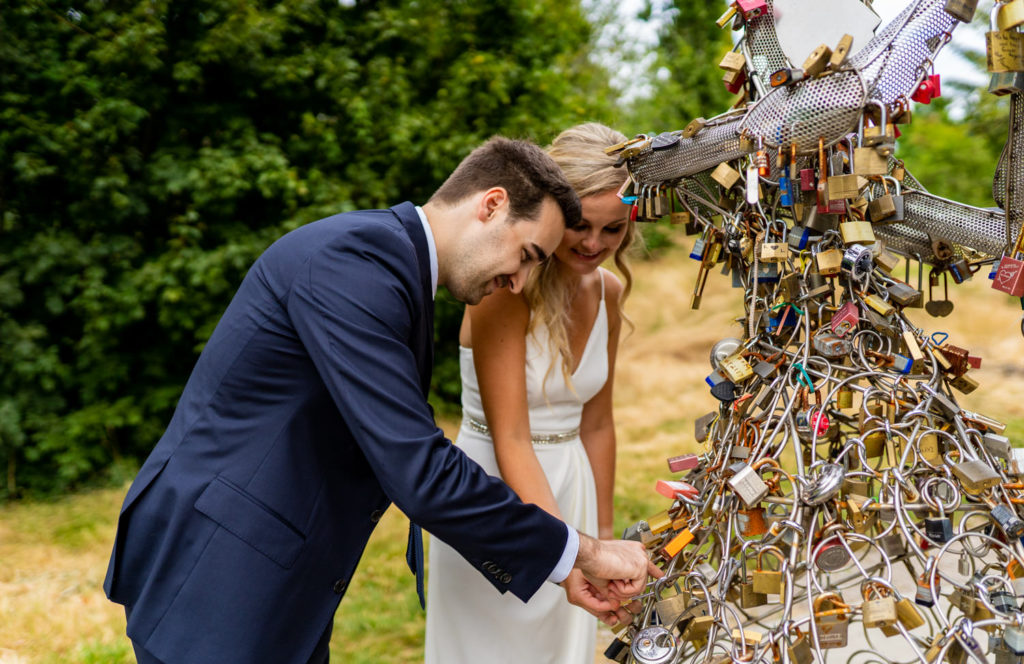 bride and groom placing a love lock at Queen Elizabeth Park