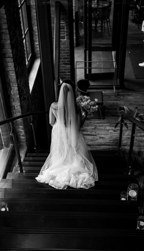 brides dress flowing as she walks down the stairs 