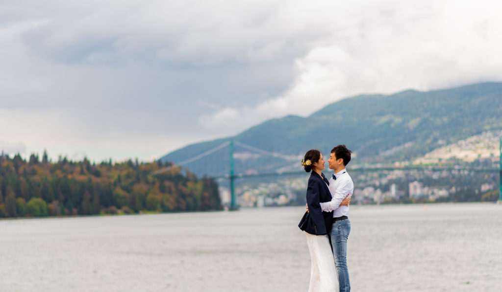 Lions Gate bridge in the background during Stanley Park engagement
