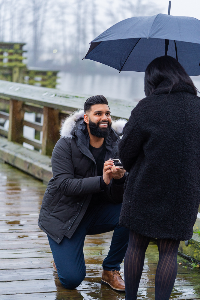 Boyfriend on one knee as he proposes to his girlfriend at Riverfront