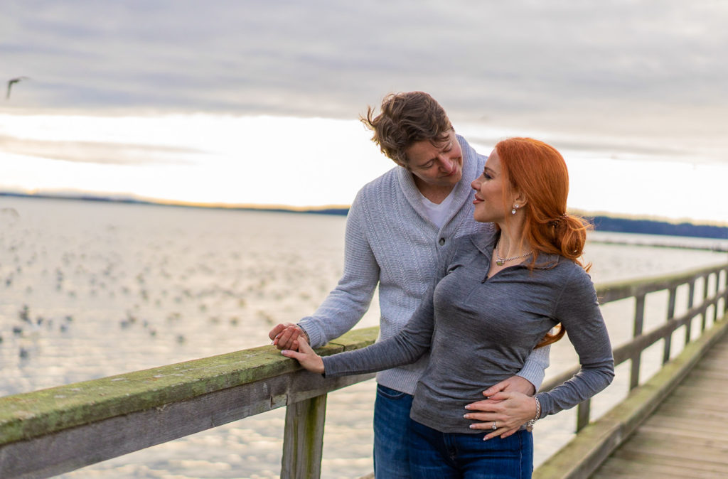 Couple cuddling for their White Rock Pier engagement session
