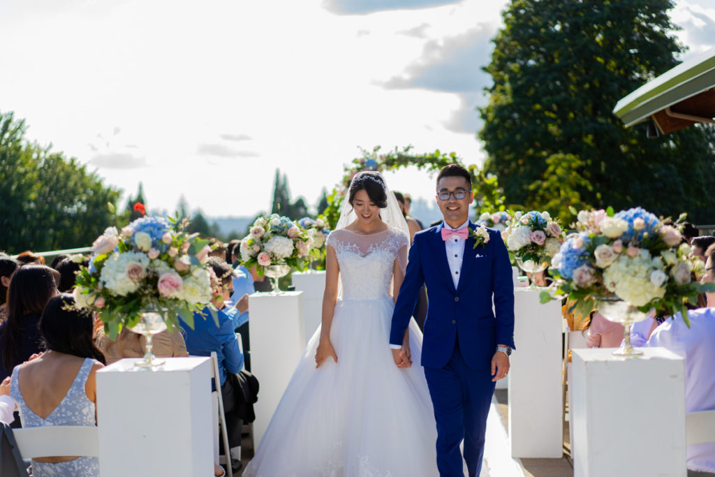 Bride and groom walking down during their Vancouver Golf Club ceremony