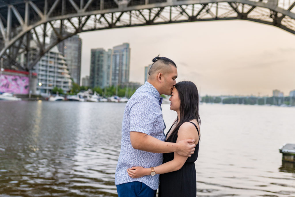fiancé kissing his partner on the forehead at Granville Island