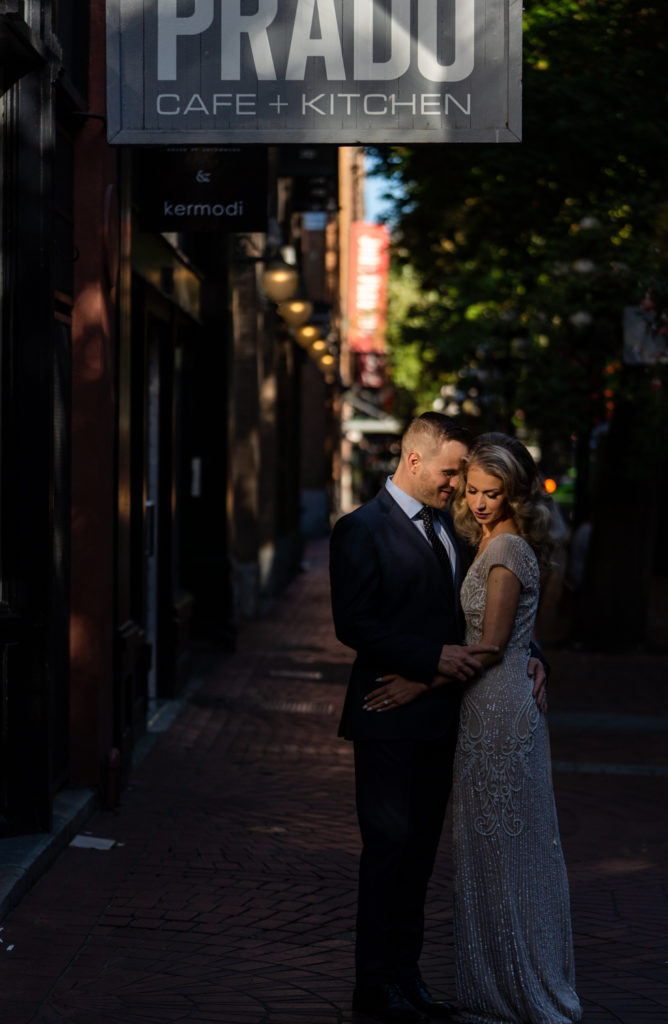 couple embracing each other in Gastown after their wedding